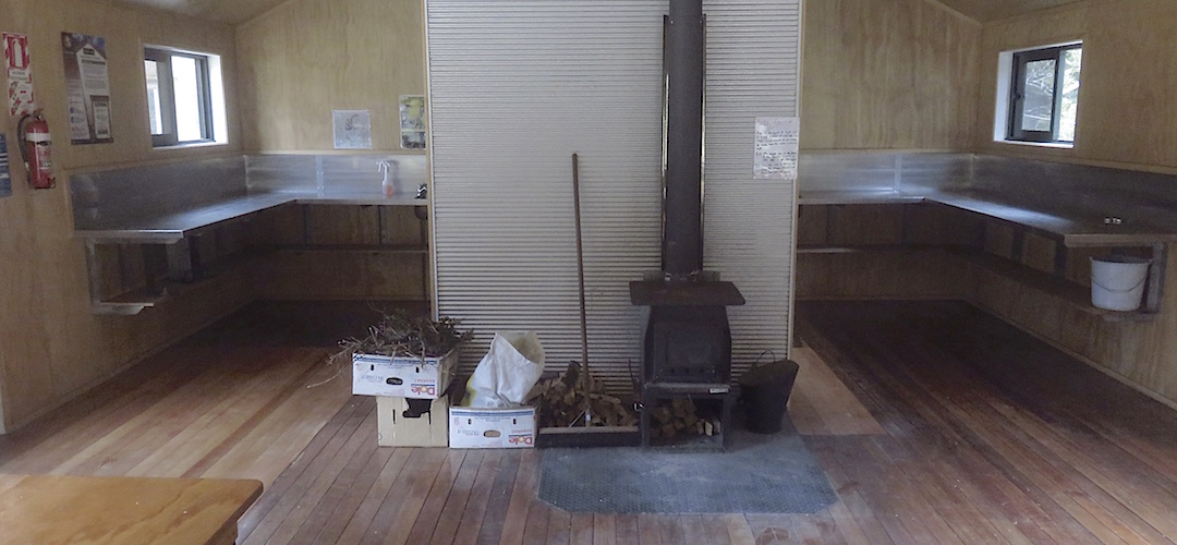 The kitchen area is behind the firebox.  | McKellar Hut, Greenstone Track