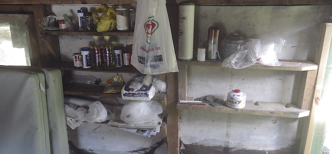 Someone has installed shelving which has been stocked up.  | Slip Flat Hut, Greenstone Track