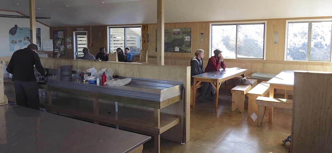 Everyone relaxing at the end of a standard tramping day. | Luxmore hut, Kepler Track, Fiordland National Park