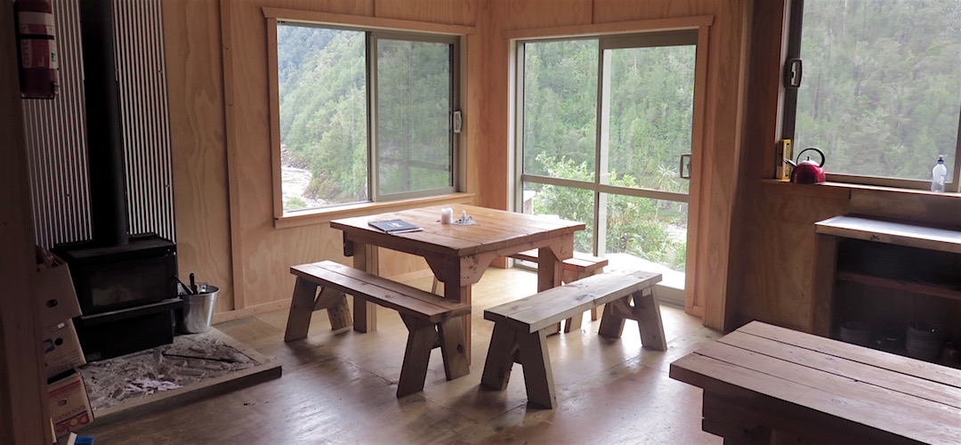 For once the main seating area has some view. | Specimen Point Hut, Mohikinui Ecological Area