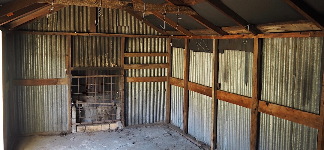 The fireplace has been blocked off, and bunks removed. | Bluff Dump Hut, Seymour Stream