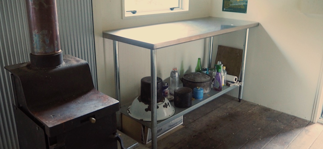 Kitchen bench, and wood burner. | Top Leatham Hut, Leatham River
