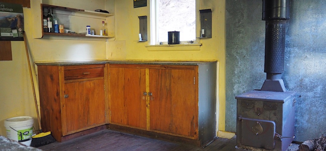 In the middle are the kitchen bench, the wood burner and another mattress. | Jollie Brook Hut, Lake Sumner Forest Park