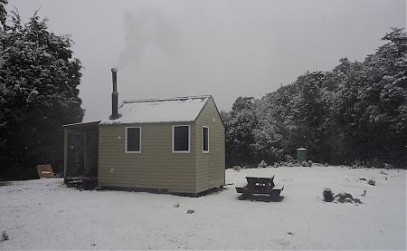 The fire's going in Old Man Hut, with the snow coming down.  | Mt Richmond Forest Park circuit, April 2018