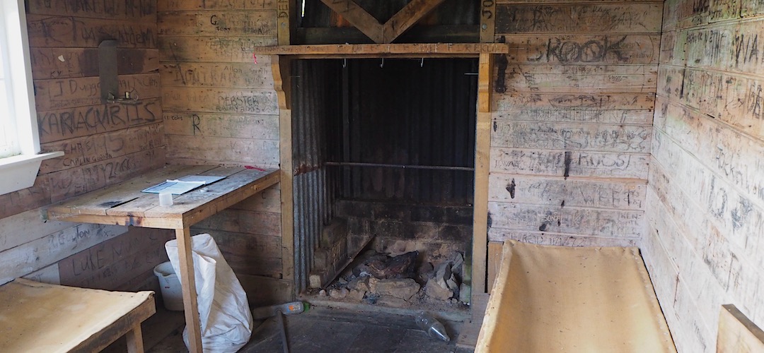 Open fireplace and three hessian bunks. | Croesus Top Hut, Croesus Track, Westland