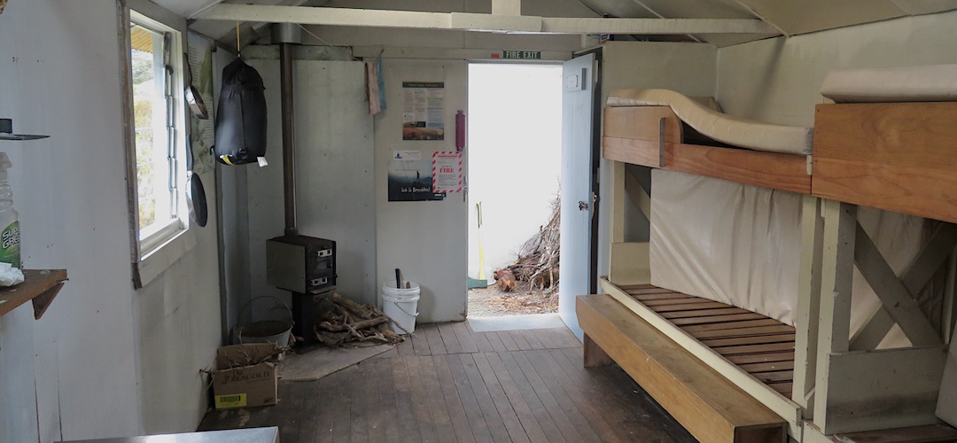 That's a tiny wood burner, but it throws out the heat. | Harman Hut, Arahura River, West Coast