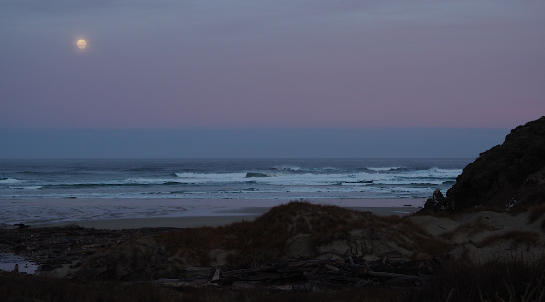 Full moon setting into the Tasman Sea at Little Hellfire Beach. | Northwest Circuit, Rakiura National Park