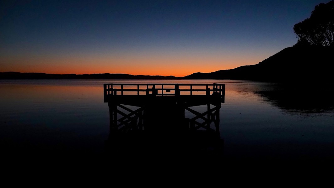 Sunrise over the Freds Camp jetty on Patterson Inlet. | Southern Circuit, Rakiura National Park