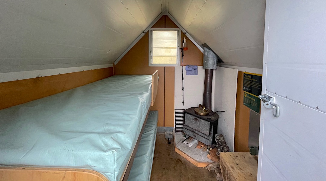 Tiny wood burner and well-sandwiched bunks. | Turkey Nest Bivvy, South Marlborough