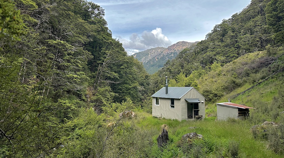 The hut is perched above the river. | Mid Silverstream Hut, Leatham Conservation Area