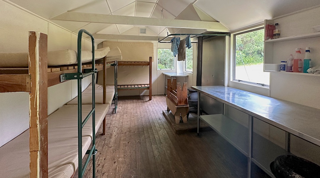 Bunks and wood burner. | Kowhai Hut, Ka Whata Tu o Rakihouia Conservation Park