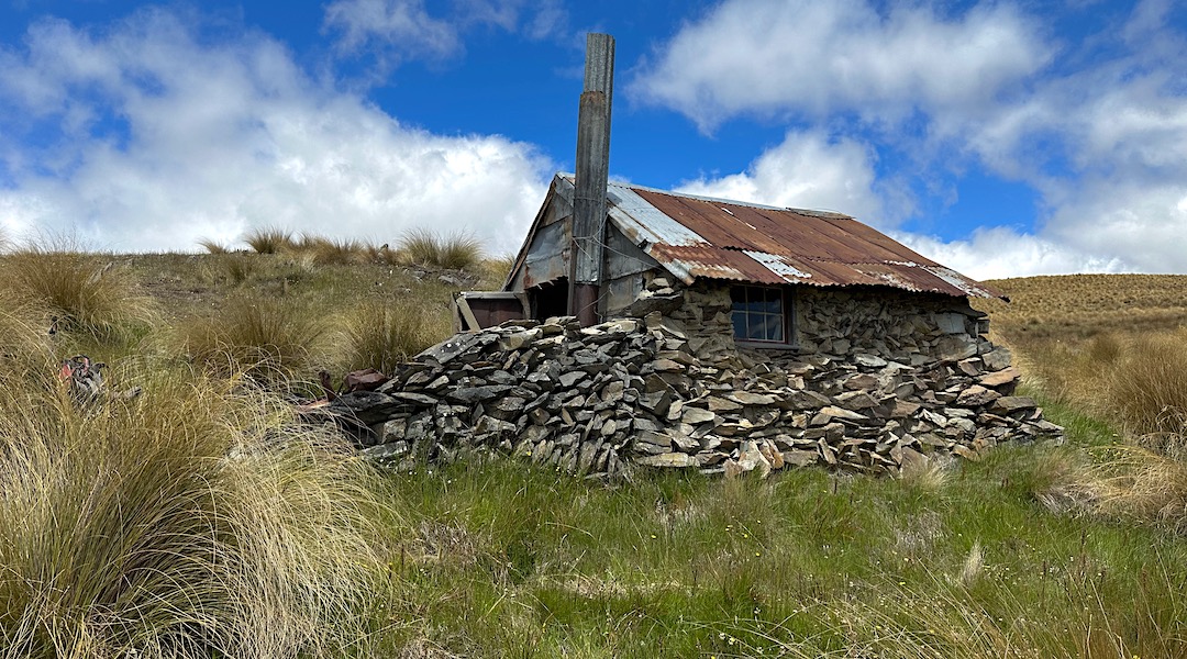 The stone helps protect from the wind. | Garden Gully Hut, Oteake Conservation Park