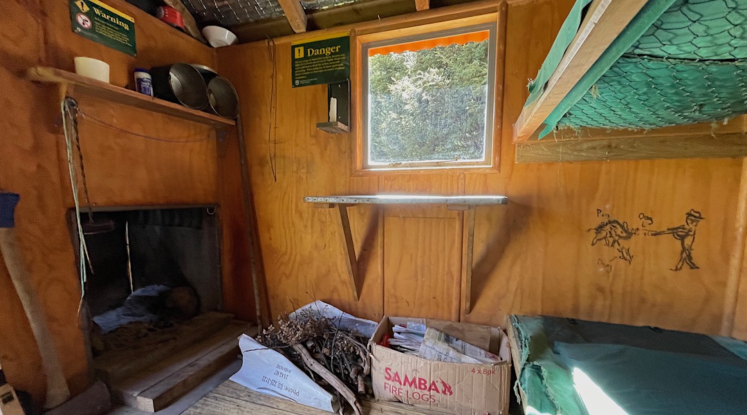 Small open fire, new window, and graffiti. | Stony Stream Bivvy, Hanmer Forest Park