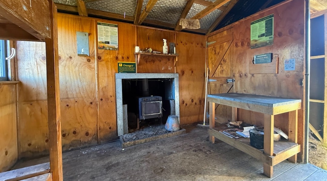 The open fire was replaced with a woodburner to save fuel. | Tarn Hut, Puketeraki Forest Conservation Area
