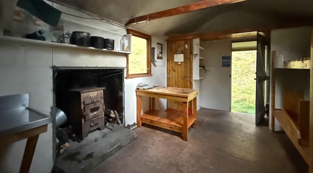 The open fire has been replaced with a woodburner. | Youngmans Stream Hut, Puketeraki Forest Conservation Area