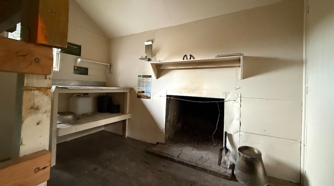 The open fire and new stainless steel benchtop. | Islands Hut, Eyre Mountains/Taka Rā Haka Conservation Park
